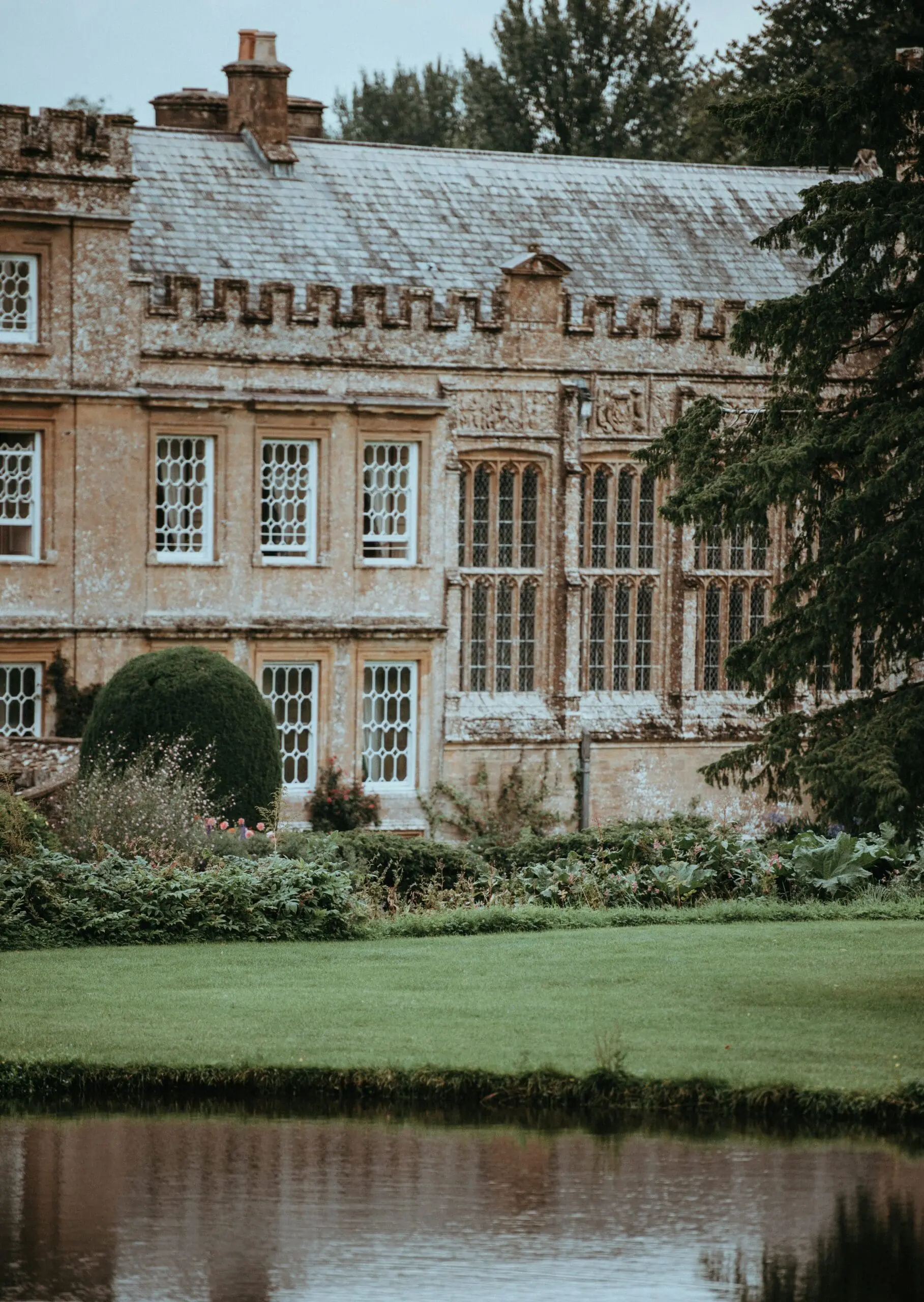 old house with grass and a pond